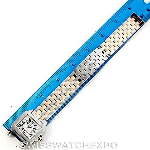 The image shows the Cartier Santos Demoiselle W25067Z6 Women's Steel and Gold (two tone) Silver Dial W25067Z6 Women's Steel and Gold (two tone) Silver Dial watch laid flat next to a blue ruler, highlighting the watch's face and bracelet.