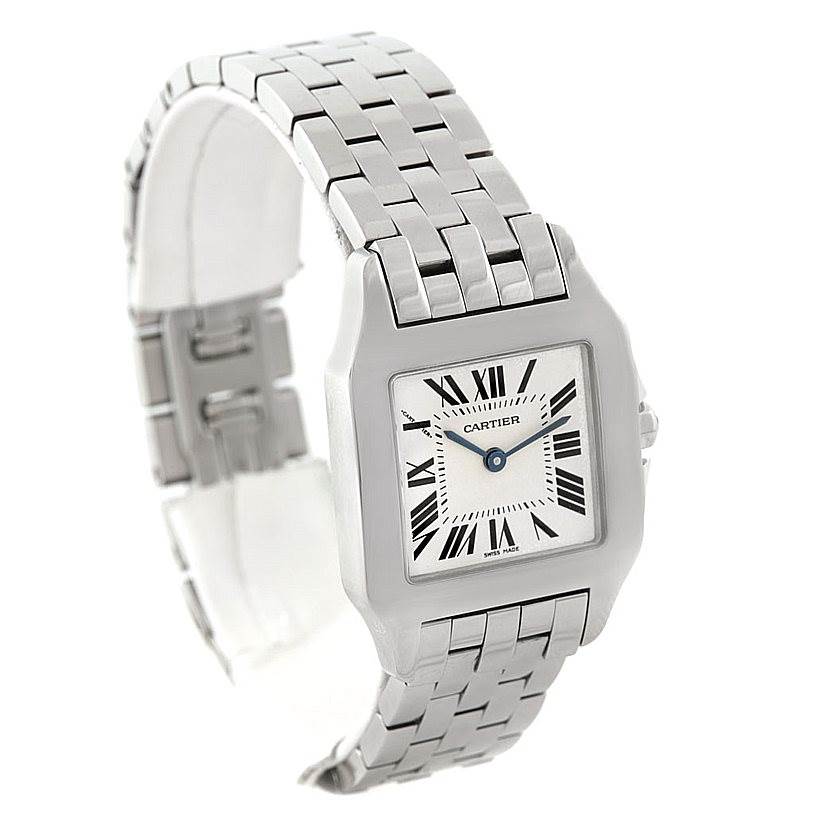 The image shows a Santos Demoiselle watch by Cartier from a three-quarter angle, highlighting the face, bezel, and metal bracelet.