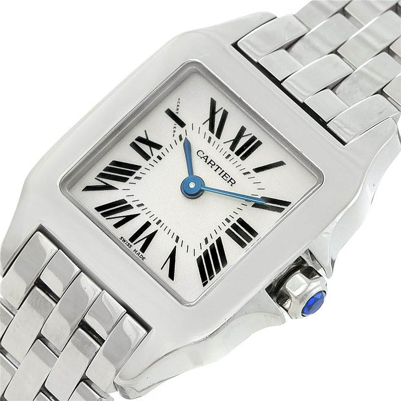 The image shows a close-up angle of the dial, case, crown, and part of the bracelet of a Cartier Santos Demoiselle W25064Z5 Women
s Stainless Steel Silver Dial W25064Z5 Women
s Stainless Steel Silver Dial watch.