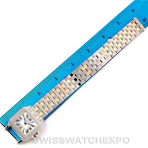 This Cartier Santos Demoiselle W25067Z6 Women's Steel and Gold (two tone) Silver Dial W25067Z6 Women's Steel and Gold (two tone) Silver Dial watch is shown face-up with its entire band extended alongside a blue ruler for scale.
