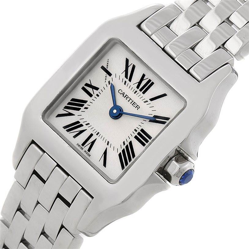 The image shows a close-up of the Cartier Santos Demoiselle W25064Z5 Women's Stainless Steel Silver Dial W25064Z5 Women's Stainless Steel Silver Dial watch, highlighting the square face, Roman numerals, and metal band.