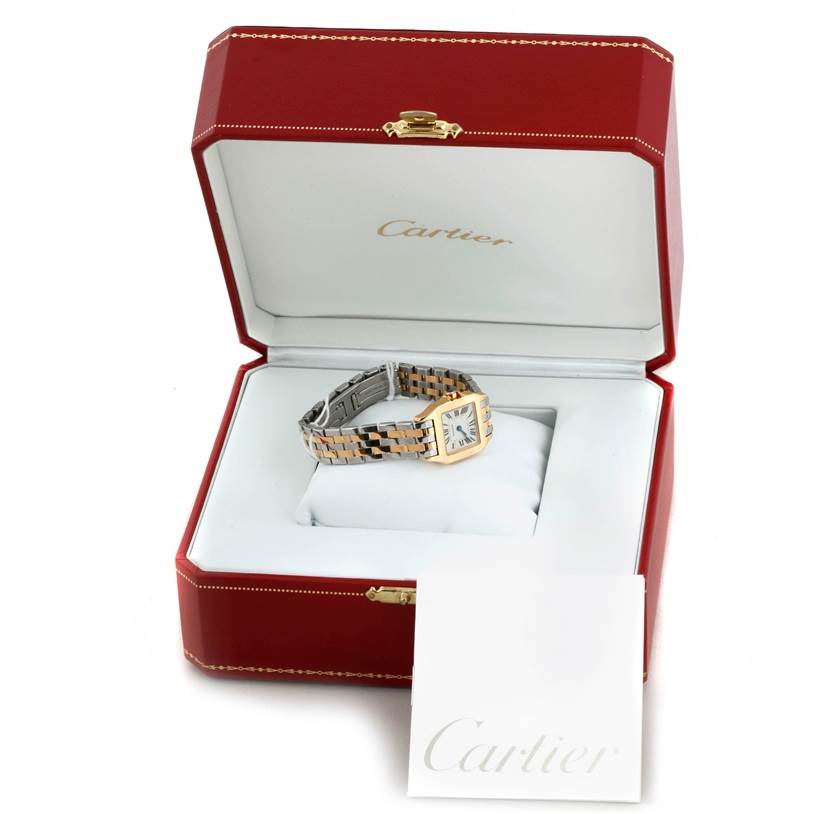 The Cartier Santos Demoiselle W25063Z6 Women's Yellow Gold Silver Dial W25063Z6 Women's Yellow Gold Silver Dial watch is displayed in an open red and white Cartier box, showing the dial and metal bracelet.