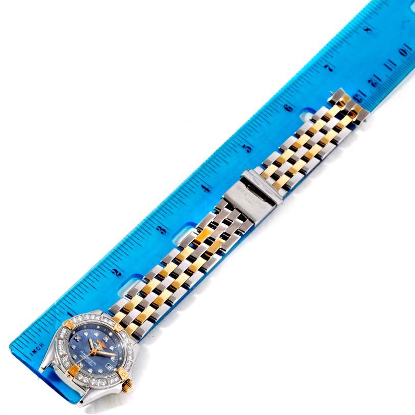 The Breitling B72345 Women's Stainless Steel Mother of Pearl Dial B72345 Women's Stainless Steel Mother of Pearl Dial Callisto Ladies Steel Gold MOP Diamond Watch A72345 is shown from a top view, highlighting the face and bracelet next to a ruler.