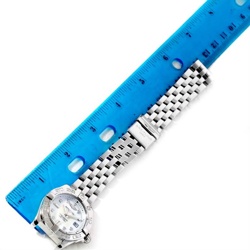 The image shows a Breitling A71356 Women's Stainless Steel Mother of Pearl Dial A71356 Women's Stainless Steel Mother of Pearl Dial Windrider Cockpit Ladies Mother Pearl Diamond Watch A71356 laying flat with a blue ruler for scale.