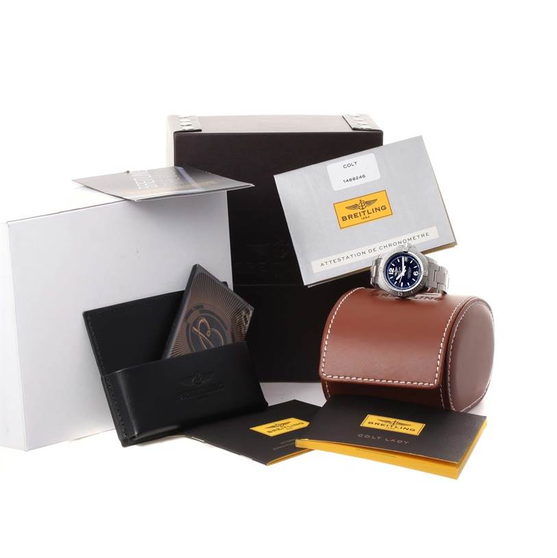 The image shows the Breitling A77388 Women's Stainless Steel Black Dial A77388 Women's Stainless Steel Black Dial Colt Lady Black Dial Steel Womens Watch A77388 Unworn model with its packaging and accessories from a side angle.
