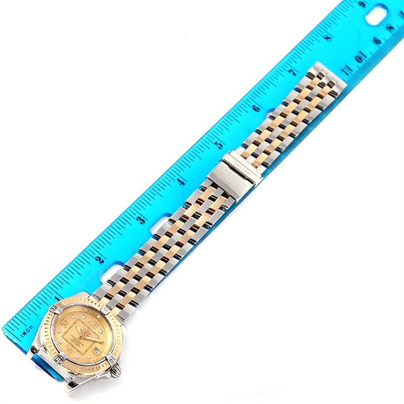 The Breitling QUARTZ MOVEMENT Women's Stainless Steel Champagne Dial QUARTZ MOVEMENT Women's Stainless Steel Champagne Dial Cockpit Ladies Steel Yellow Gold Diamond Watch D71356 is shown from a top-down angle, next to a measuring ruler.