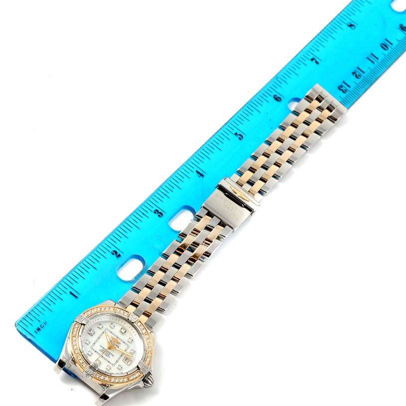 The Breitling D71356 Women's Stainless Steel Mother of Pearl Dial D71356 Women's Stainless Steel Mother of Pearl Dial Cockpit Ladies Steel 18K Yellow Gold Diamond Watch D71356 is shown from a top view with a ruler beside it.