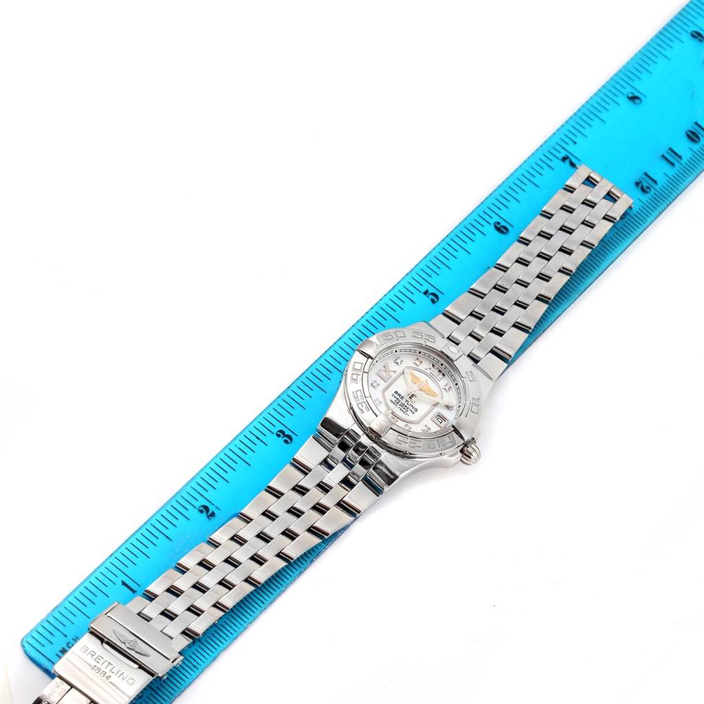 The image shows a Breitling A71340 Women's Stainless Steel Mother of Pearl Dial A71340 Women's Stainless Steel Mother of Pearl Dial Starliner Mother of Pearl Diamond Dial Ladies Watch A71340 laid flat beside a blue ruler.