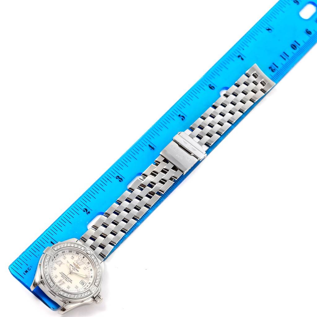 The image shows the Breitling A71365 Women's Stainless Steel Mother of Pearl Dial A71365 Women's Stainless Steel Mother of Pearl Dial B-Class MOP Diamond Dial Bezel Women's Watch A71365 model laid flat next to a ruler, displaying its dial, bezel, and bracelet.