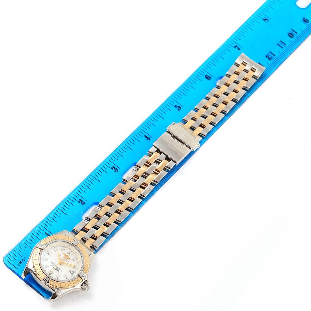 The Breitling D72345 Women's Stainless Steel Mother of Pearl Dial D72345 Women's Stainless Steel Mother of Pearl Dial Windrider Calisto D72345 is shown flat with the strap extended, positioned next to a blue ruler for scale.