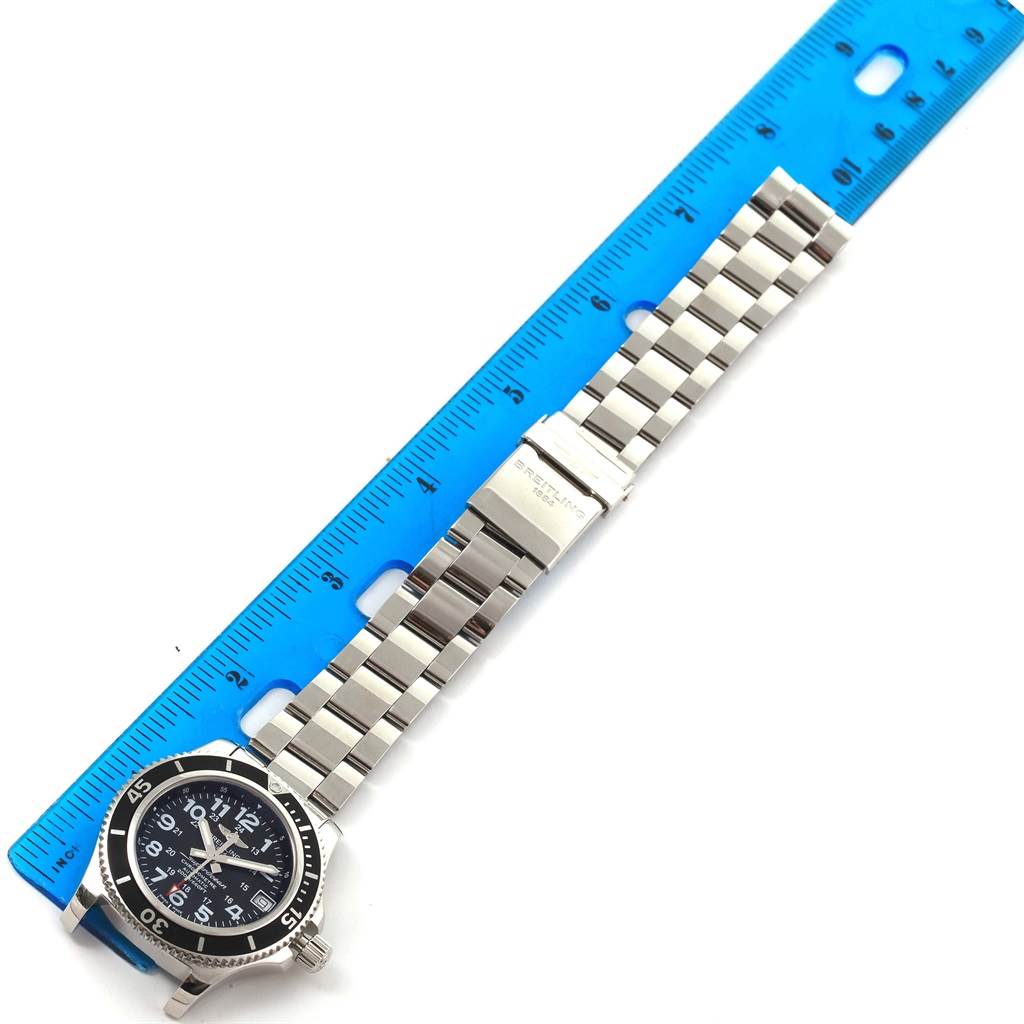 The Breitling A17312 Women's Stainless Steel Black Dial A17312 Women's Stainless Steel Black Dial Superocean II 36 A17312 watch is shown laid flat with the front dial and bracelet visible against a ruler for scale.