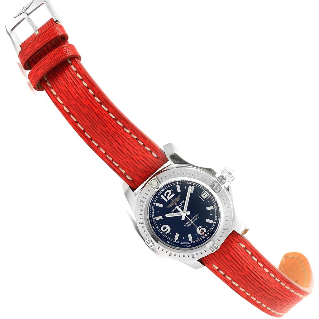 The Breitling A74389 Women's Stainless Steel Black Dial A74389 Women's Stainless Steel Black Dial Colt 36 Quartz Steel Mens Watch A74389 is shown at an angle displaying its face, crown, and red leather strap with a buckle.