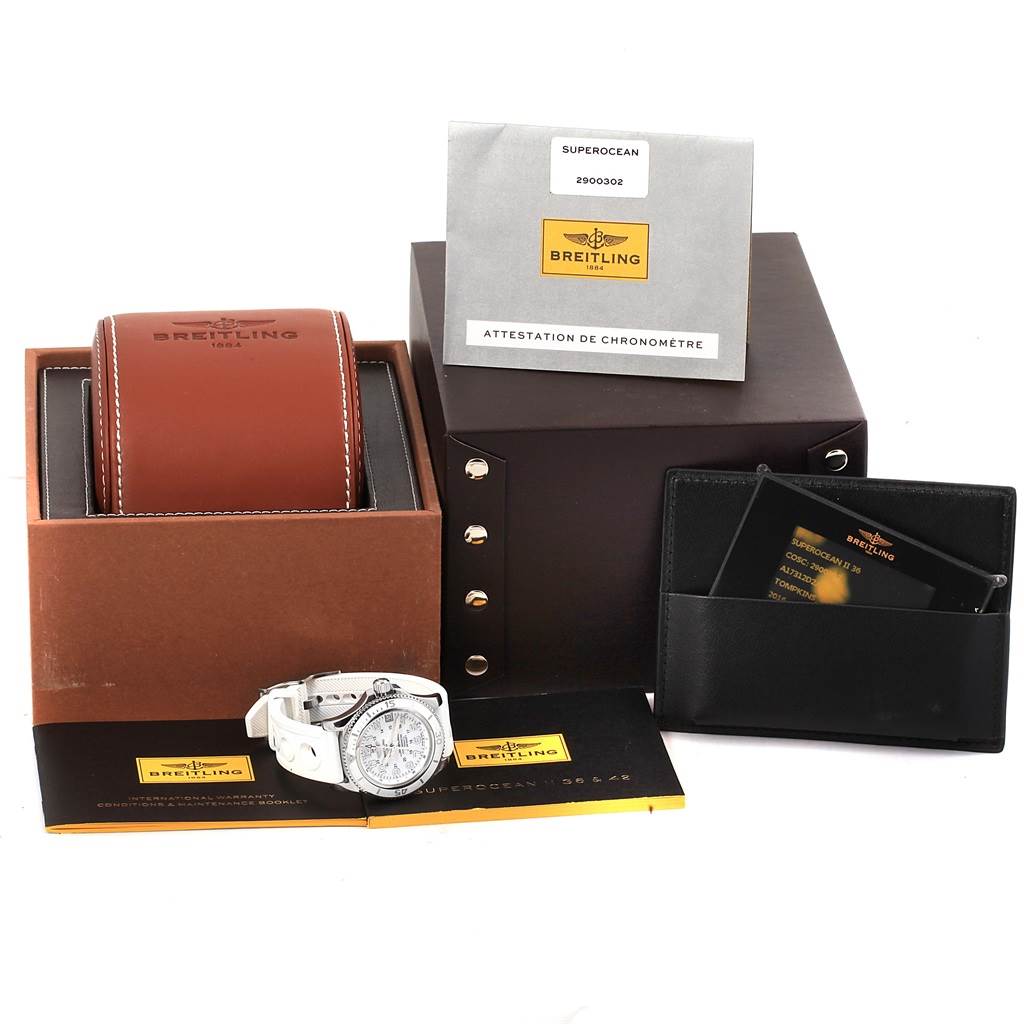 The image shows a Breitling A17312D2/A775/230S Women's Stainless Steel White Dial A17312D2/A775/230S Women's Stainless Steel White Dial Superocean II 36 White Rubber Strap Watch A17312 alongside its box, papers, and accessories.