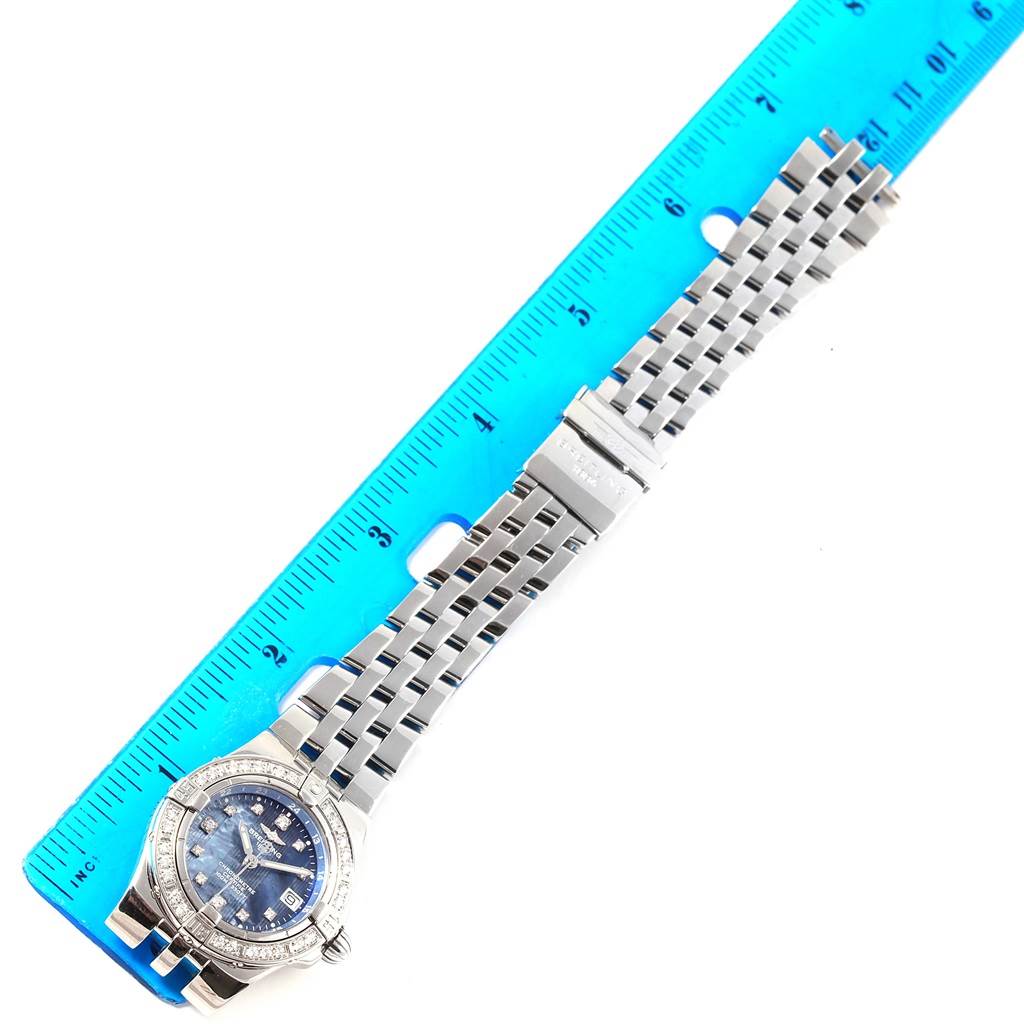 The Breitling A71340 Women
s Stainless Steel Mother of Pearl Dial A71340 Women
s Stainless Steel Mother of Pearl Dial Starliner Blue Mother of Pearl Diamond Watch A71340 is shown in a top-down angle, highlighting the face, bracelet, and a measuring ruler.