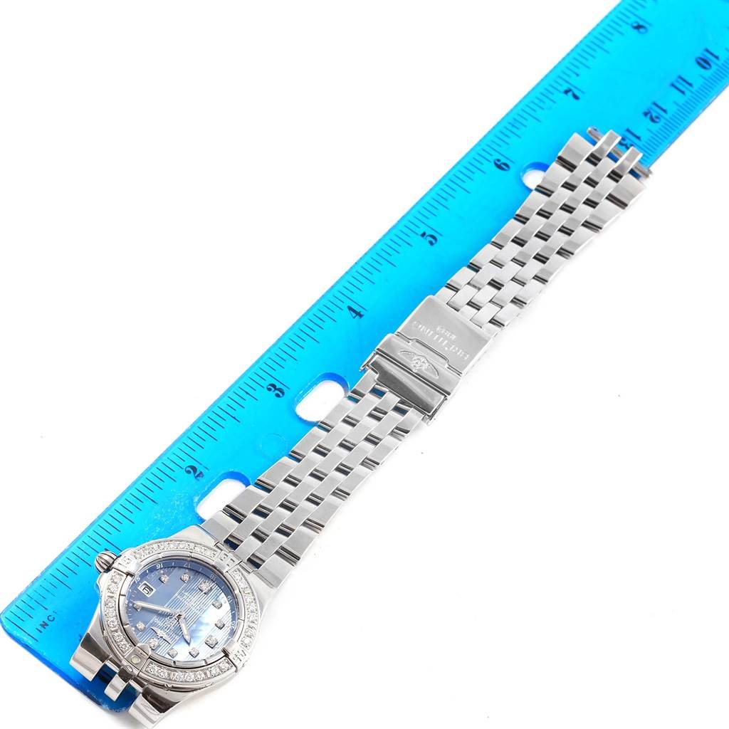 This image shows the Breitling A71340 Women's Stainless Steel Mother of Pearl Dial A71340 Women's Stainless Steel Mother of Pearl Dial Starliner Blue MOP Diamond Ladies Watch A71340 laid flat next to a blue ruler for scale.