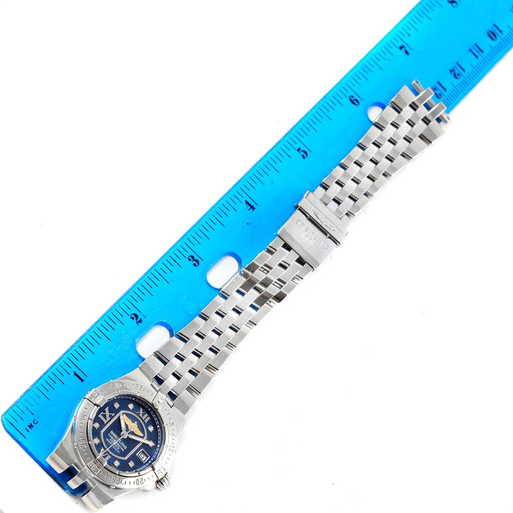 The Breitling A71340 Women's Stainless Steel Blue Dial A71340 Women's Stainless Steel Blue Dial Starliner Blue Diamond Dial Steel Ladies Watch A71340 is laid flat next to a blue ruler, showing the face and entire band.