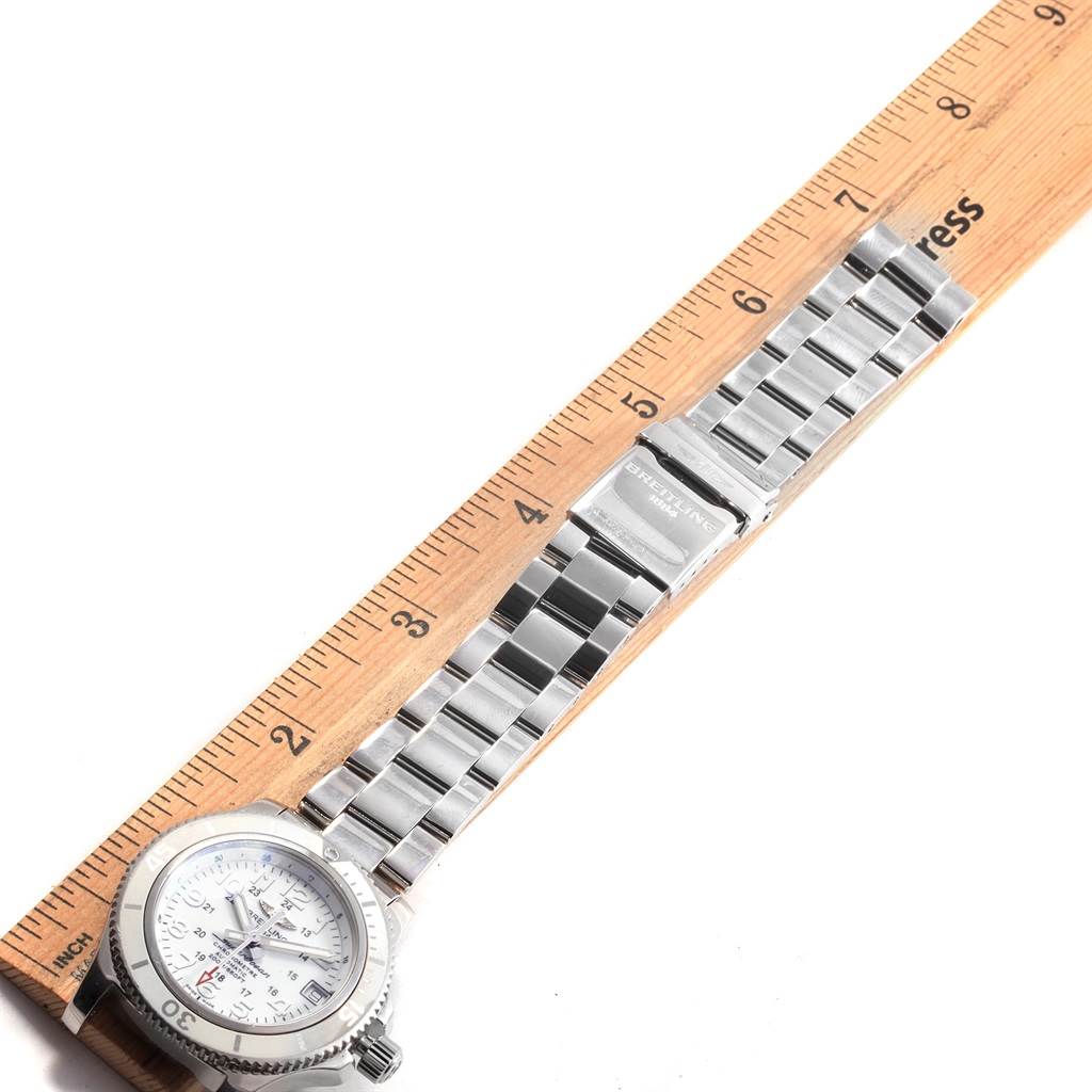 The image shows the Breitling A17312D2/A775/179A Women's Stainless Steel White Dial A17312D2/A775/179A Women's Stainless Steel White Dial Superocean II 36 Hurricane White Steel Ladies Watch A17312 laid flat next to a ruler, displaying the band and face.