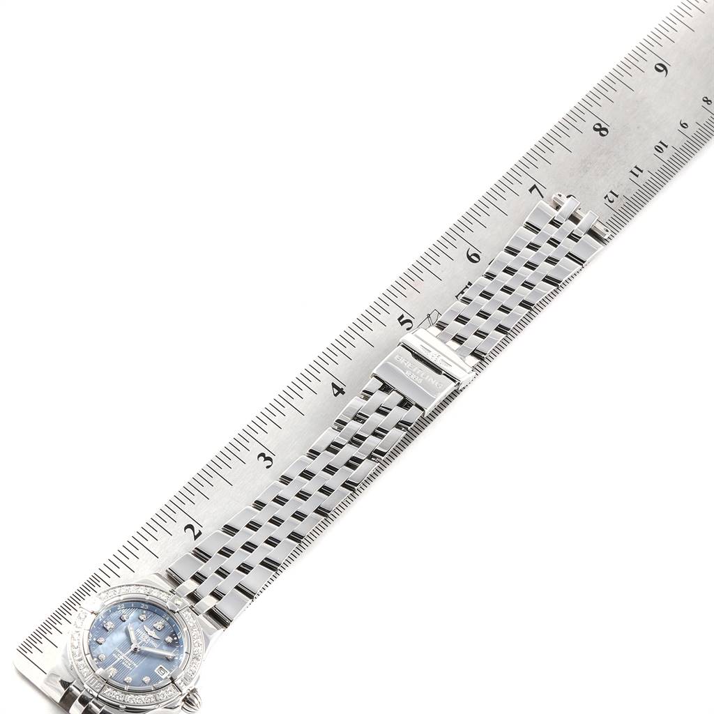 The image shows the Breitling A71340 Women's Stainless Steel Mother of Pearl Dial A71340 Women's Stainless Steel Mother of Pearl Dial Starliner Blue MOP Diamonds Ladies Watch A71340 laid alongside a ruler, displaying its dial, bezel, and bracelet.