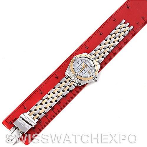 The image shows a top-down view of the Breitling D7135612 Women
s Stainless Steel Mother of Pearl Dial D7135612 Women
s Stainless Steel Mother of Pearl Dial Cockpit Ladies Diamond Watch D7135612, placed next to a red ruler.