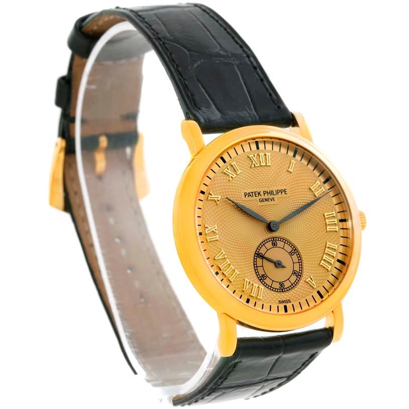 The image shows a side angle of the Patek Philippe Calatrava 5022 Men's Yellow Gold Champagne Dial 5022 Men's Yellow Gold Champagne Dial watch, highlighting its dial, case, and leather strap.