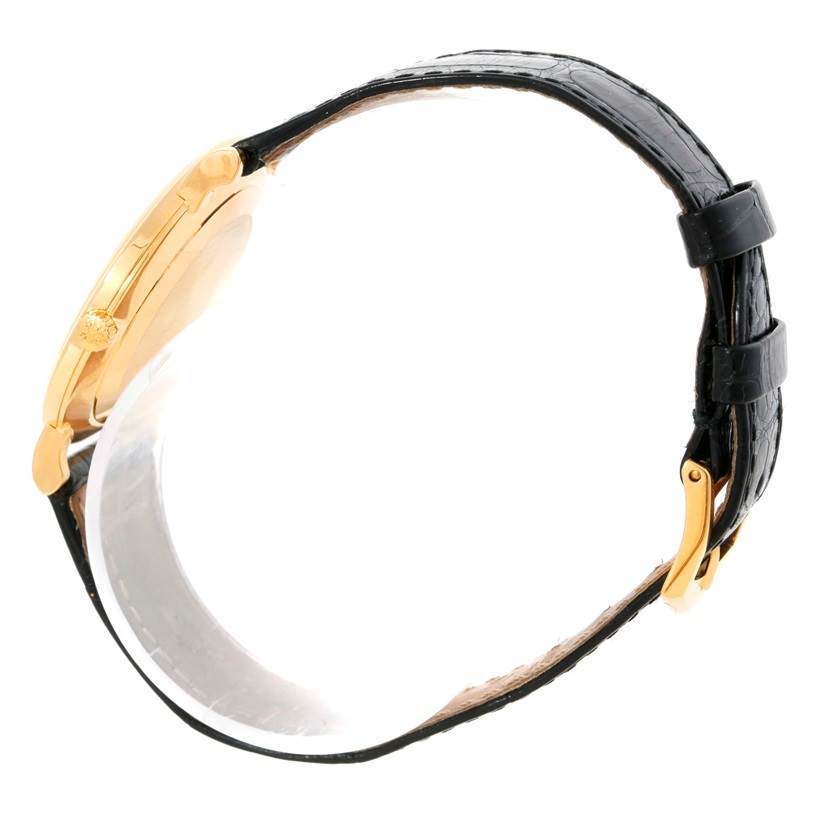 The image shows a side view of the Patek Philippe Calatrava 5022 Men's Yellow Gold Champagne Dial 5022 Men's Yellow Gold Champagne Dial watch highlighting the gold case and black leather strap.