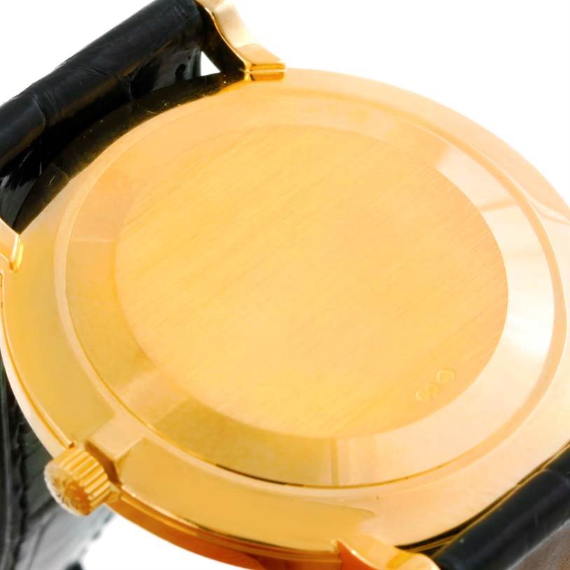 This image shows the case back of a Patek Philippe Calatrava 5022 Men's Yellow Gold Champagne Dial 5022 Men's Yellow Gold Champagne Dial watch, focusing on the gold back plate and part of the leather strap.