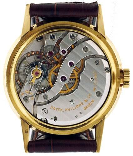 This image shows the backside of a Vintage Patek Philippe watch, exposing the internal mechanical movements and components.
