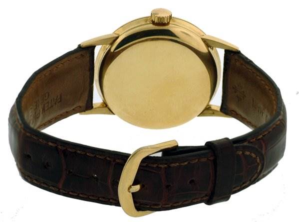 This image shows the back view of a Vintage Patek Philippe watch with a gold case and brown leather strap.