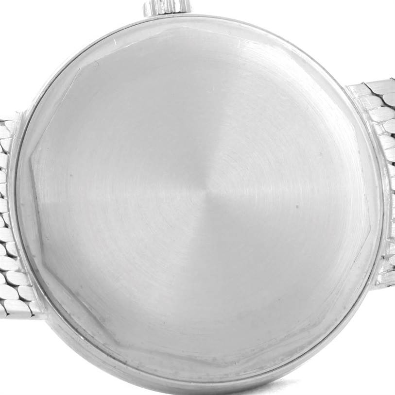 This image shows the back case of a Vintage Patek Philippe watch, focusing on its brushed metal finish and part of the wristband.