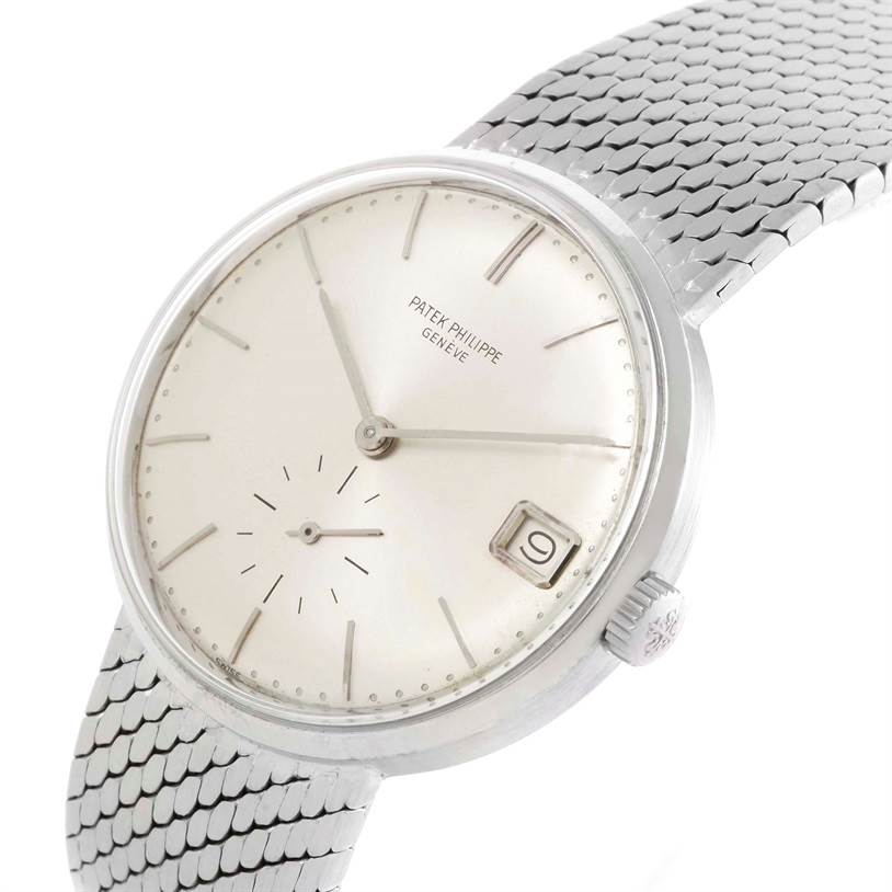 The image shows a Patek Philippe Vintage watch at an angle highlighting the dial, date window, and part of the metal strap.