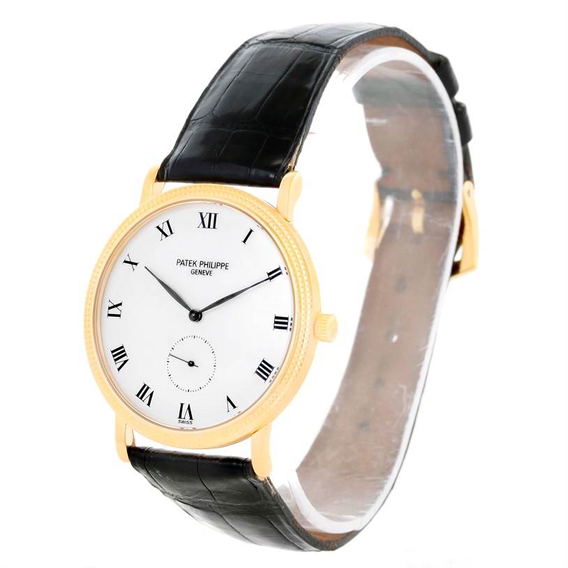 The Patek Philippe Calatrava 3919 Men's Yellow Gold White Dial 3919 Men's Yellow Gold White Dial watch is shown at an angle, displaying its face, gold case, black strap, and Roman numeral hour markers.