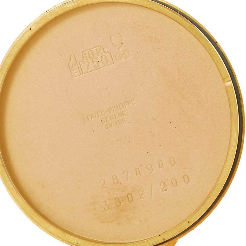 This image shows the inside of the back cover of a Calatrava model by Patek Philippe, highlighting its engravings and gold markings.