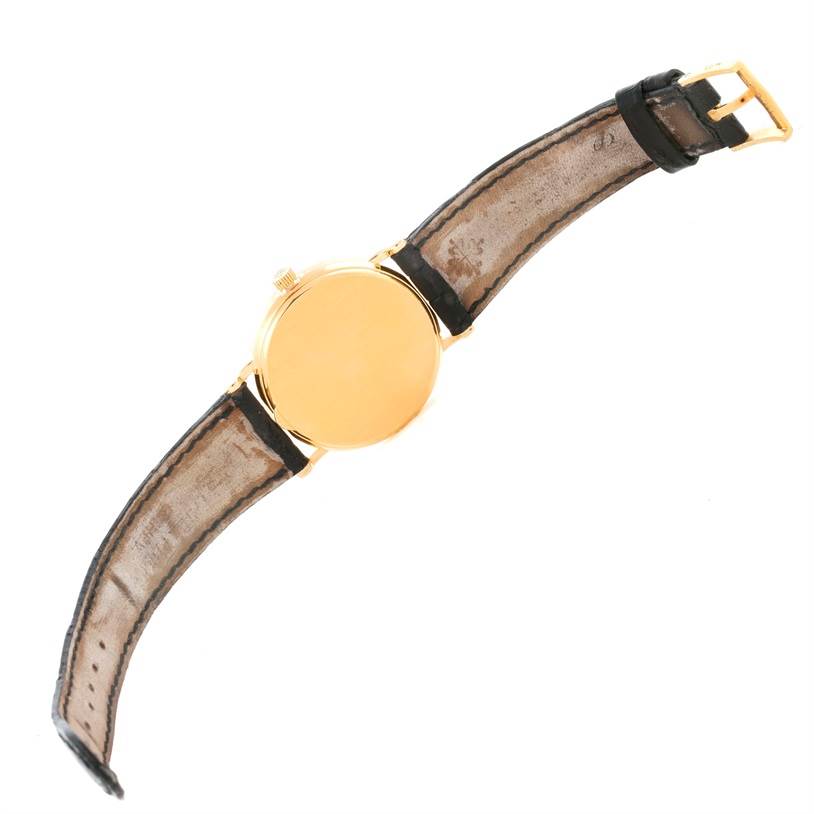 The image shows the back of a Patek Philippe Calatrava 3802 Men's Yellow Gold White Dial 3802 Men's Yellow Gold White Dial watch with its leather strap fully extended.