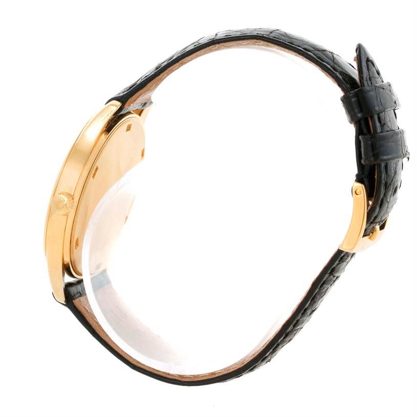 The image shows a side view of a Patek Philippe Calatrava 3998 Men's Yellow Gold Silver Dial 3998 Men's Yellow Gold Silver Dial watch, highlighting the gold case and black leather strap.