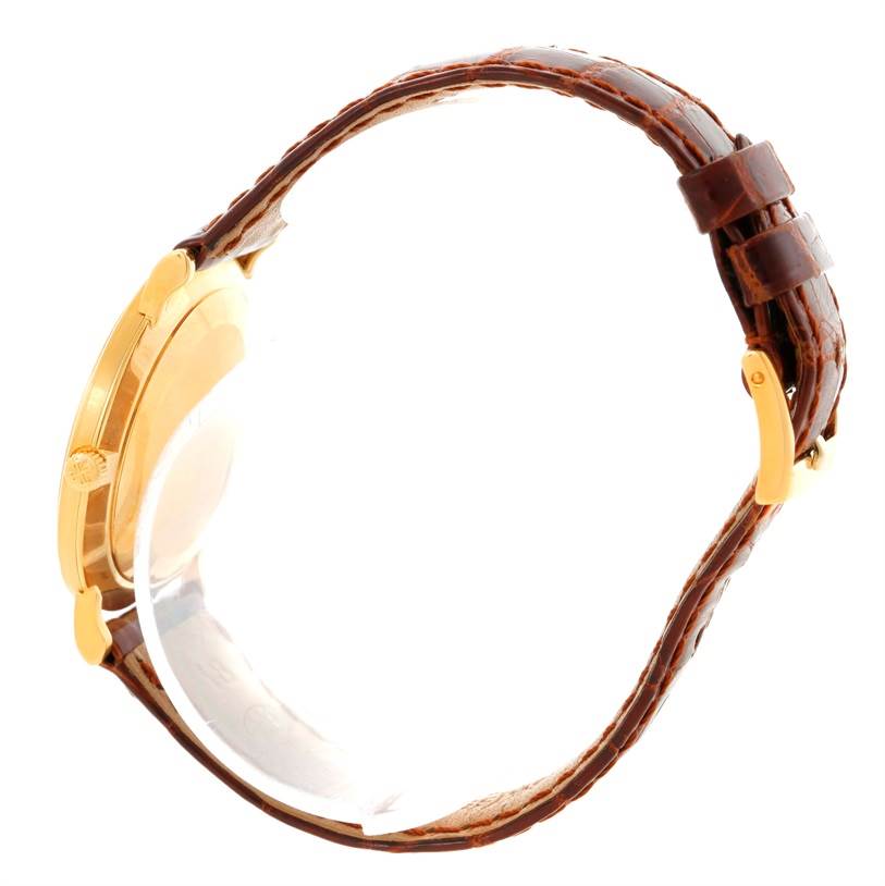 This side view of the Patek Philippe Calatrava 3919 Men's Yellow Gold White Dial 3919 Men's Yellow Gold White Dial watch shows the case, crown, and leather strap.