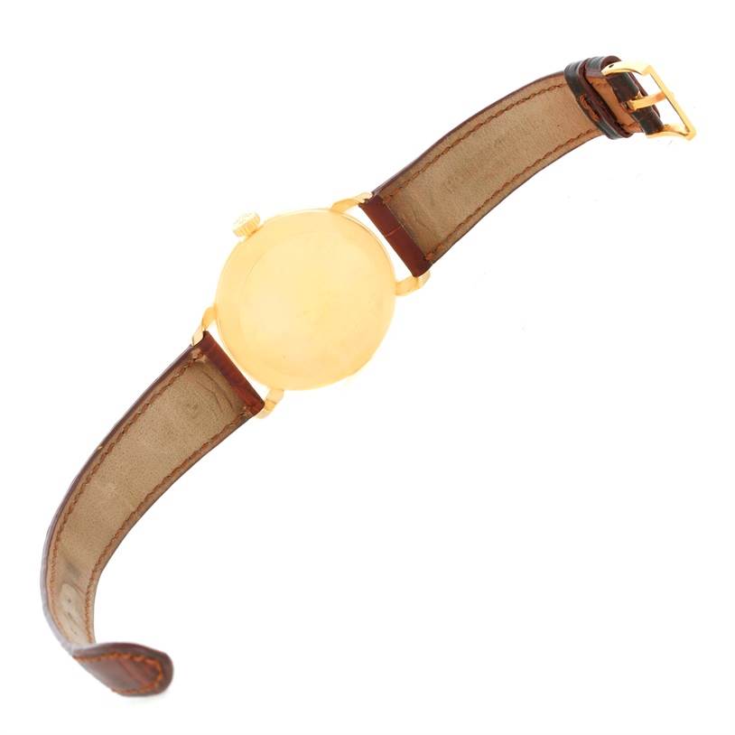 The image shows the back of a Patek Philippe 2482 Yellow Gold Silver Dial 2482 Yellow Gold Silver Dial Calatrava 18k Yellow Gold Men
s Vintage Watch 2482 model, with a leather strap and buckle.