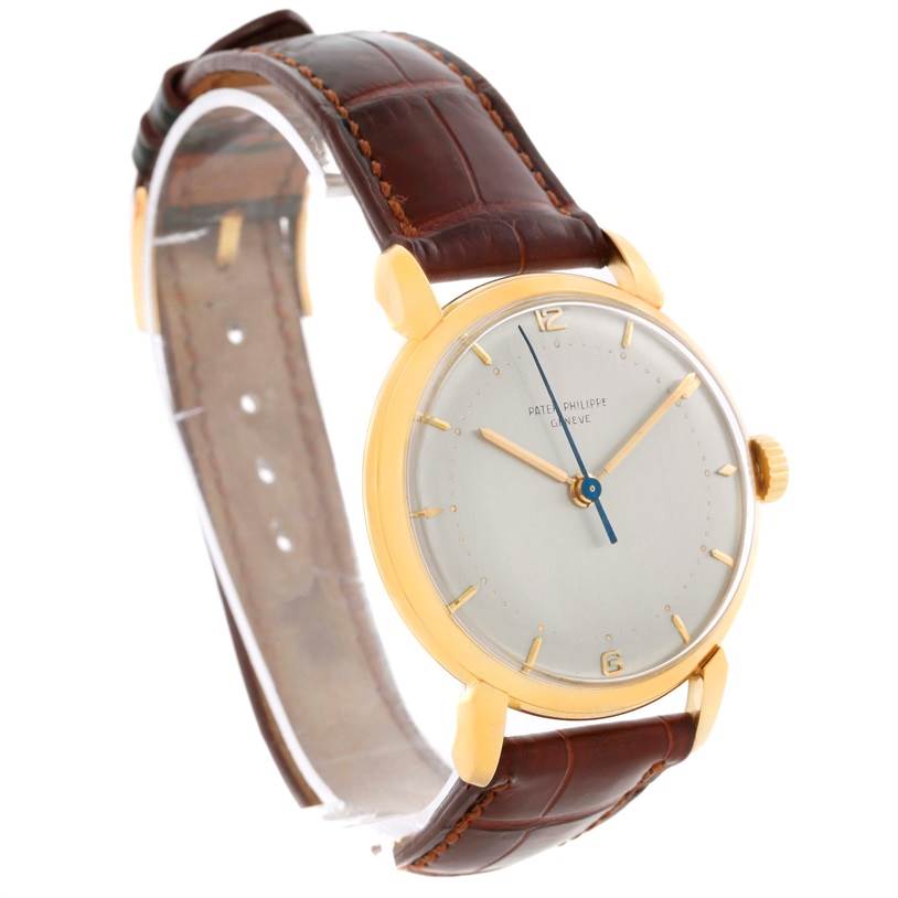 The image shows the Patek Philippe 2482 Yellow Gold Silver Dial 2482 Yellow Gold Silver Dial Calatrava 18k Yellow Gold Vintage Watch 2482 model from a front-side angle displaying its dial, hands, and brown leather strap.