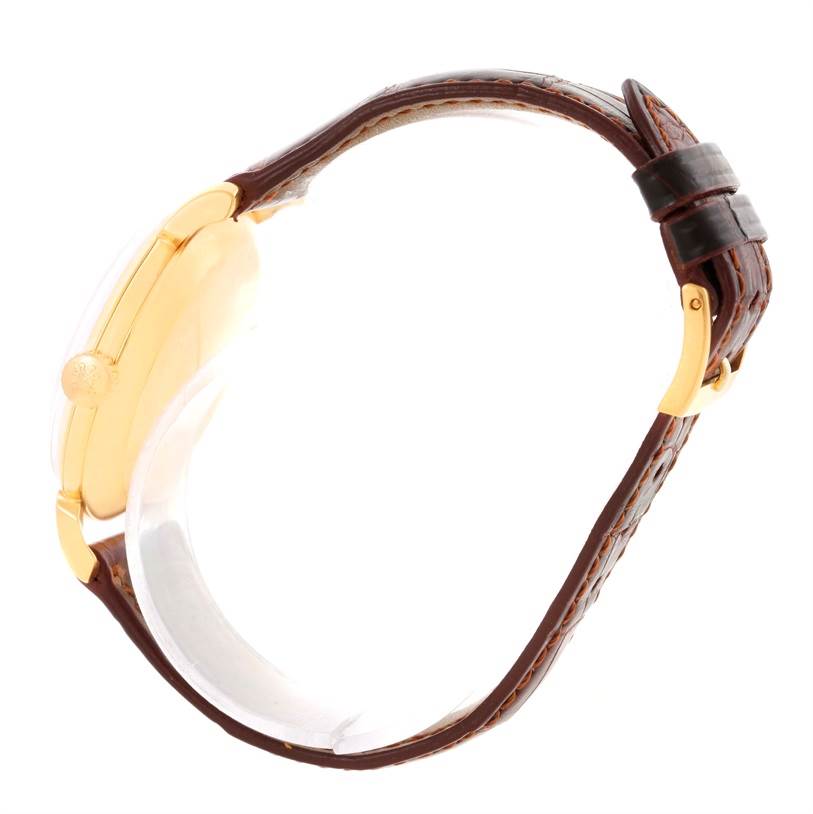 The image shows a side view of the Patek Philippe 2482 Yellow Gold Silver Dial 2482 Yellow Gold Silver Dial Calatrava 18k Yellow Gold Mens Vintage Watch 2482 with a brown leather strap and gold buckle.