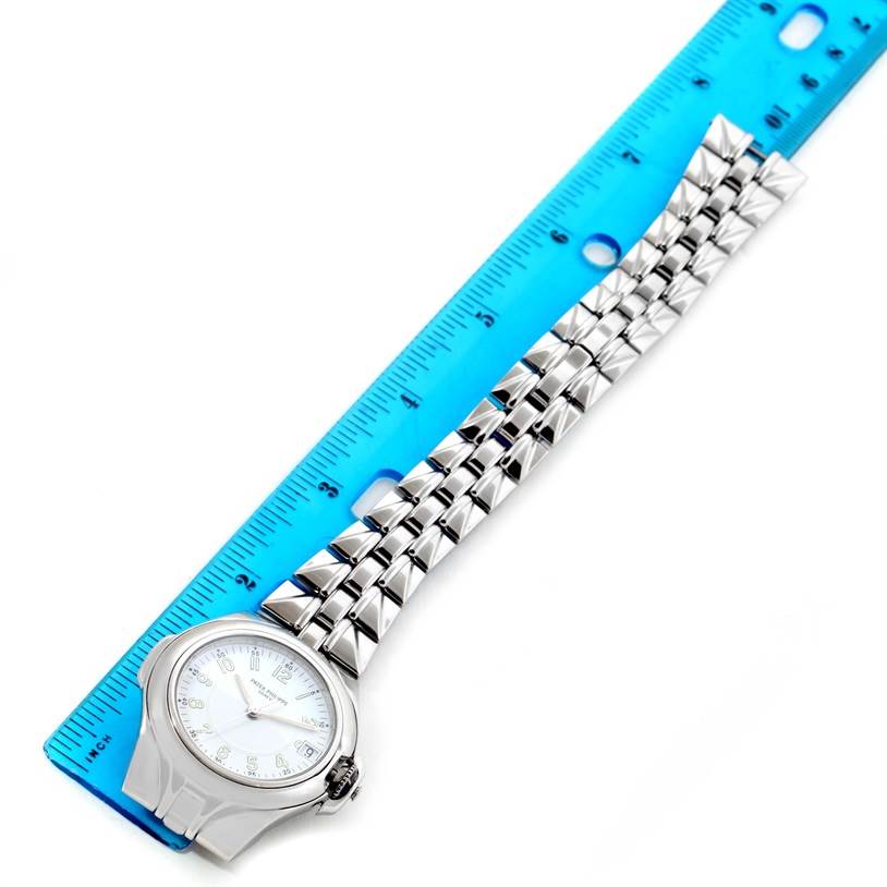 The image shows a top view of a Patek Philippe Sculpture 5091/1A-001 Women's Stainless Steel White Dial 5091/1A-001 Women's Stainless Steel White Dial model watch alongside a blue ruler.