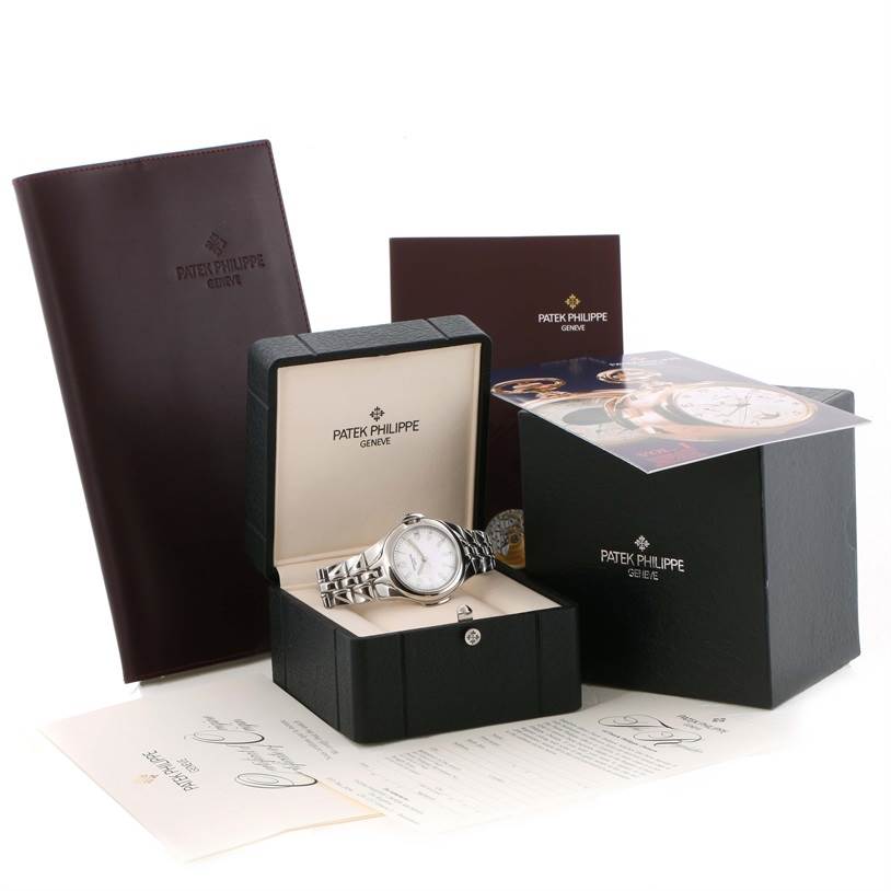The image shows a Patek Philippe Sculpture 5091/1A-001 Women's Stainless Steel White Dial 5091/1A-001 Women's Stainless Steel White Dial model watch in its box, along with accompanying booklets, certificates, and packaging.