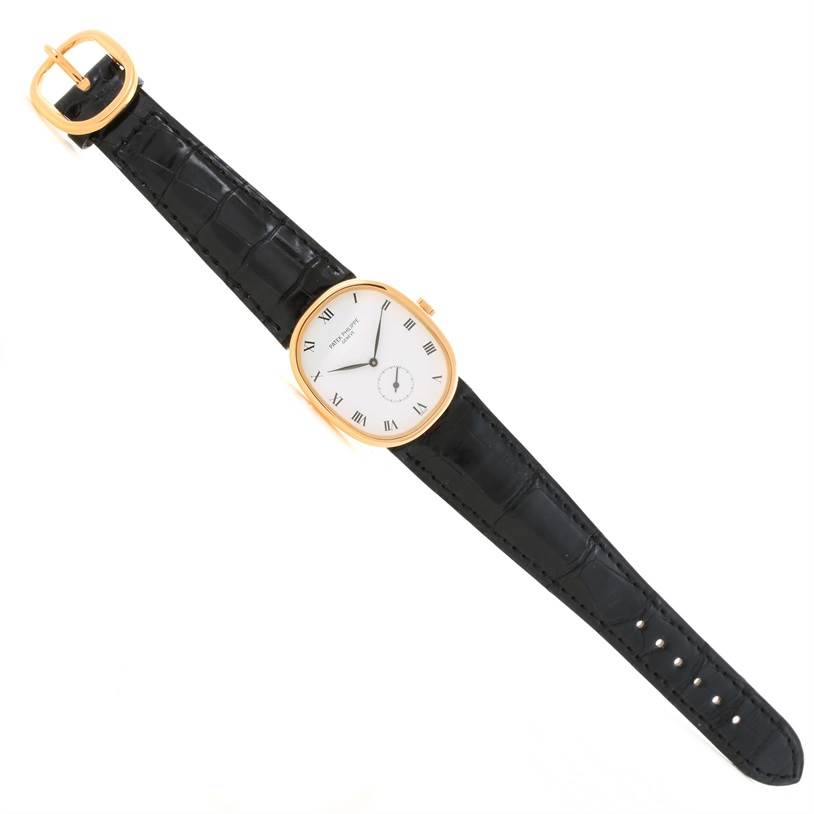 The Patek Philippe Golden Ellipse 3948 Men's Yellow Gold White Dial 3948 Men's Yellow Gold White Dial watch is shown from a top-down angle, displaying its entire gold case, dial, and black strap.