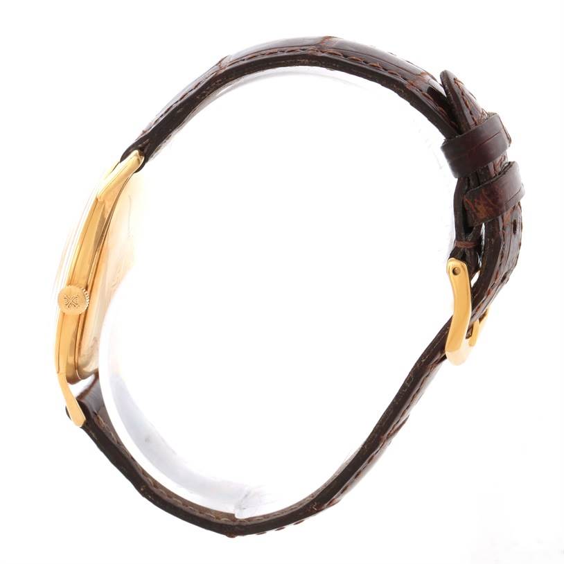 This side view shows the case, crown, and leather strap of a Vintage Patek Philippe watch.