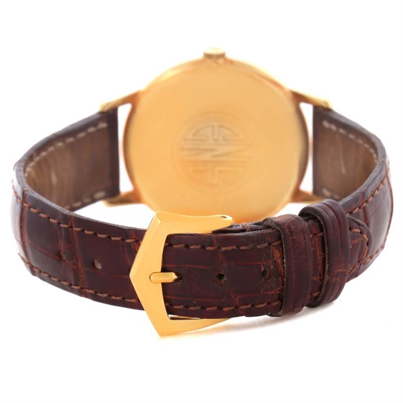 This image shows the back of the Vintage Patek Philippe watch with its brown leather strap and gold clasp.