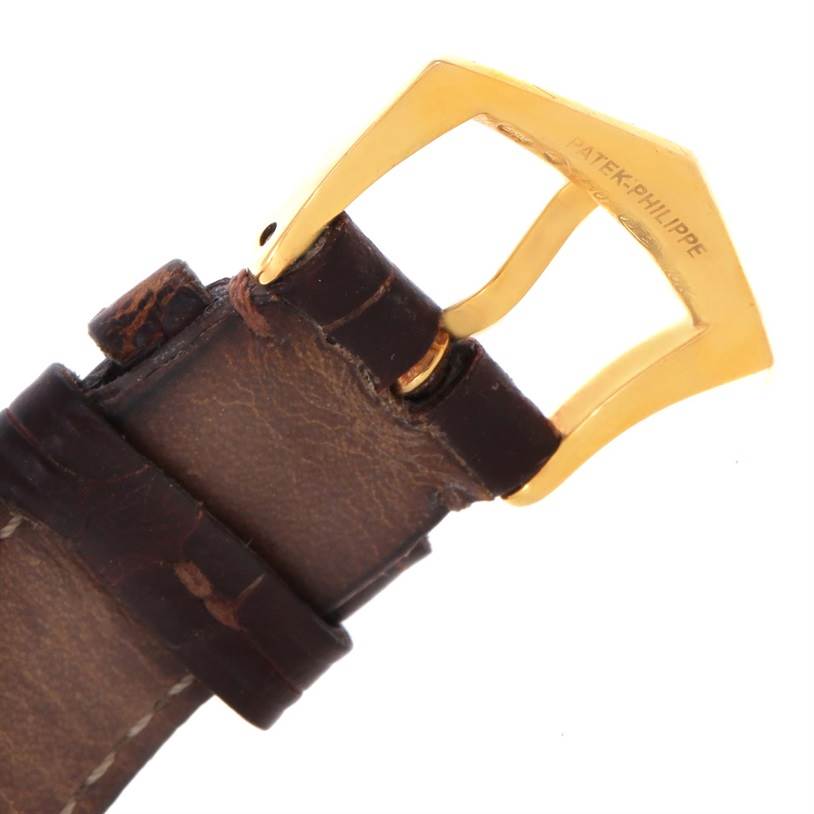 This image shows a close-up of the leather strap and gold buckle of a Vintage Patek Philippe watch.