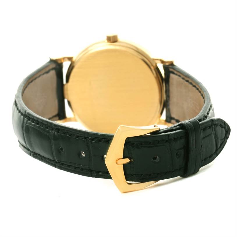 This image shows the back view of the Calatrava watch by Patek Philippe, highlighting the gold case and black leather strap with a gold buckle.