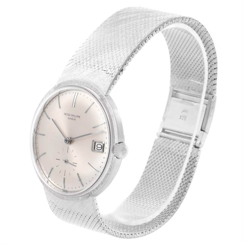 The image shows a Patek Philippe Vintage watch at a three-quarter angle, displaying the face, dial, date window, crown, and part of the metal mesh strap.