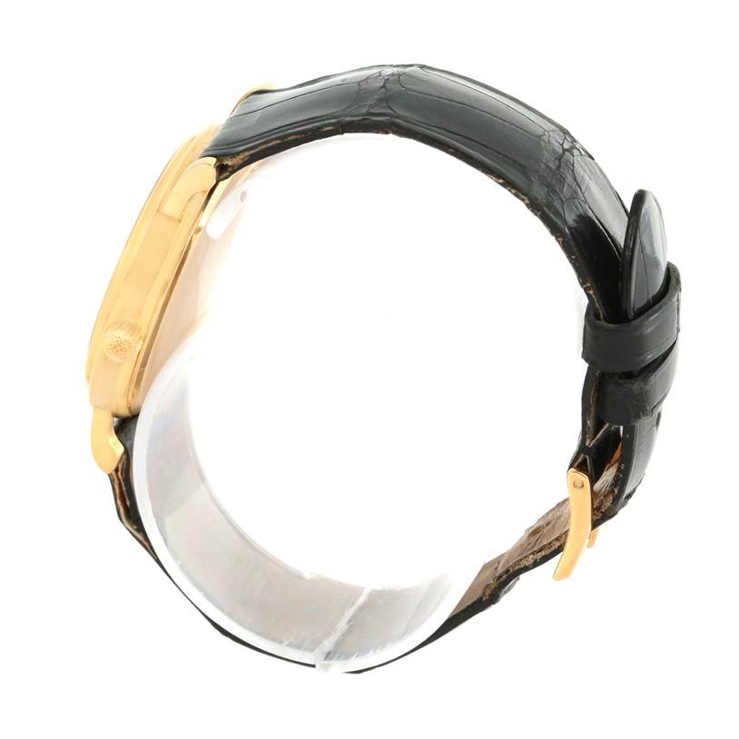 The image shows a side view of the Patek Philippe Calatrava 3802 Men's Yellow Gold White Dial 3802 Men's Yellow Gold White Dial watch with a gold case and black leather strap.