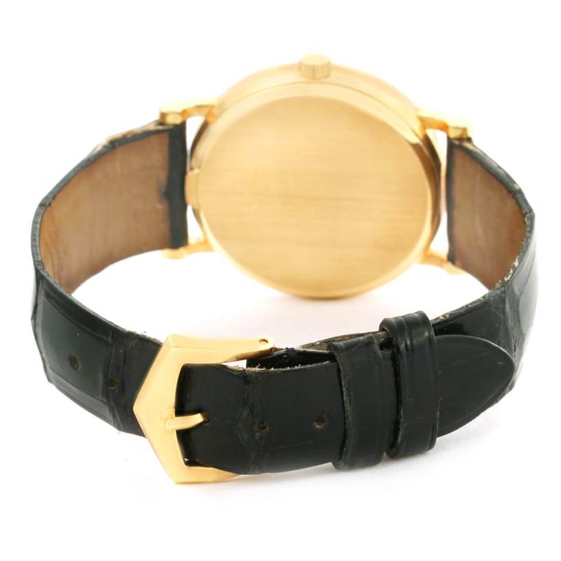 This image shows the back of a Patek Philippe Calatrava 3802 Men's Yellow Gold White Dial 3802 Men's Yellow Gold White Dial watch, highlighting its gold case and black leather strap with gold buckle.