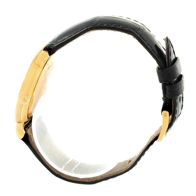 The image shows a side profile view of a Patek Philippe Calatrava 3919 Men's Yellow Gold White Dial 3919 Men's Yellow Gold White Dial watch, highlighting the gold case and black leather strap.