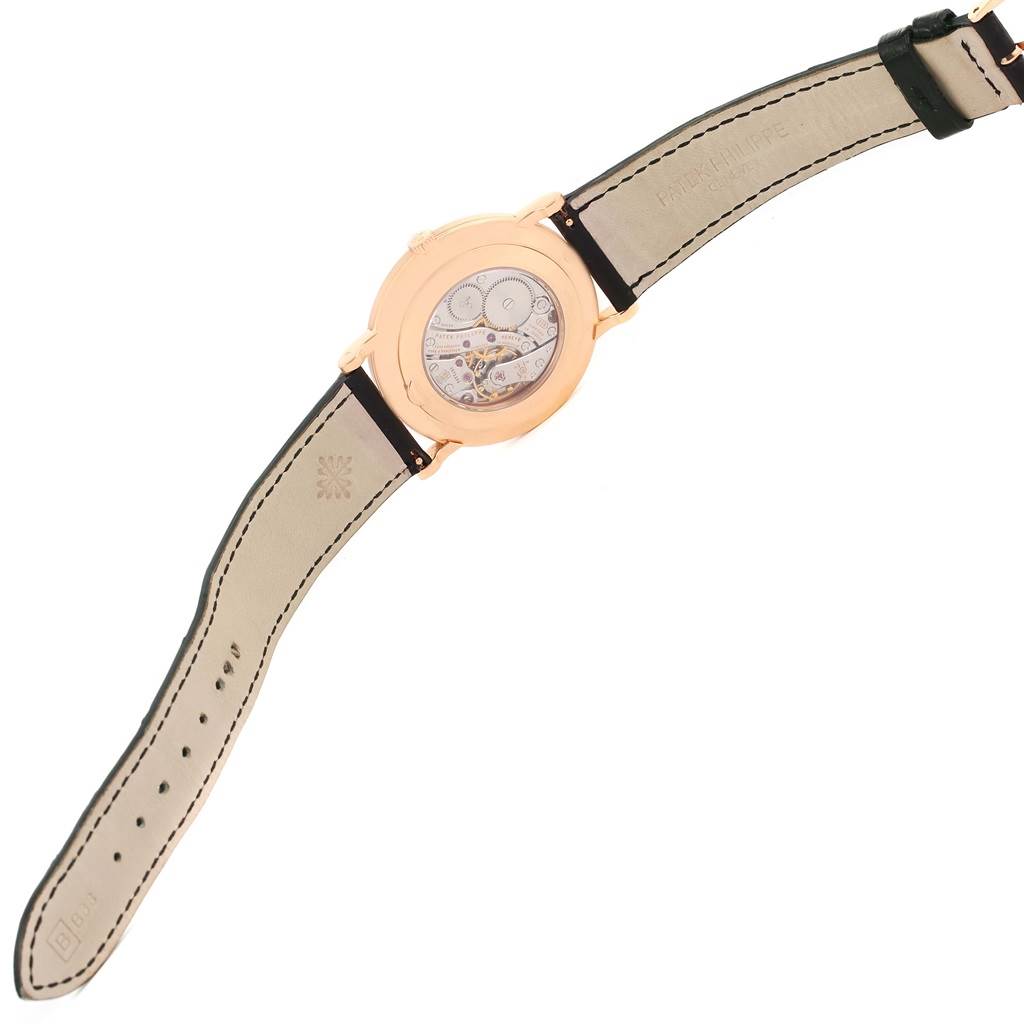 The image shows the back view of the Patek Philippe Calatrava 5119 Men
s Rose Gold White Dial 5119 Men
s Rose Gold White Dial watch, highlighting its open case back and leather strap.